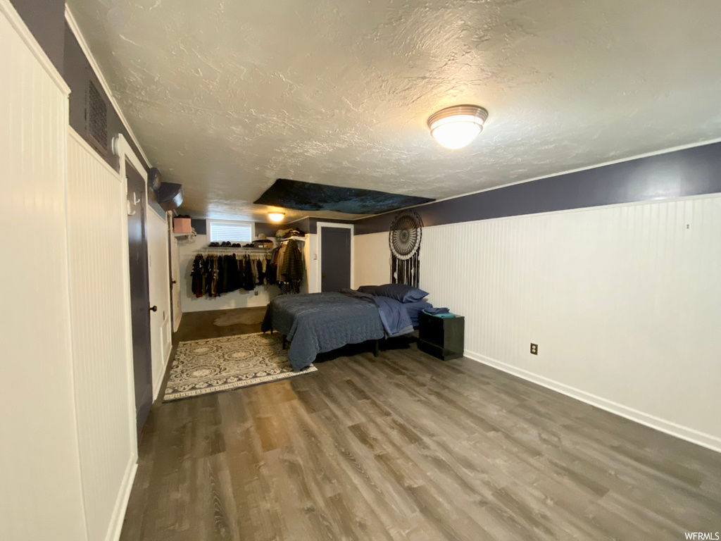 Unfurnished bedroom featuring dark hardwood / wood-style flooring