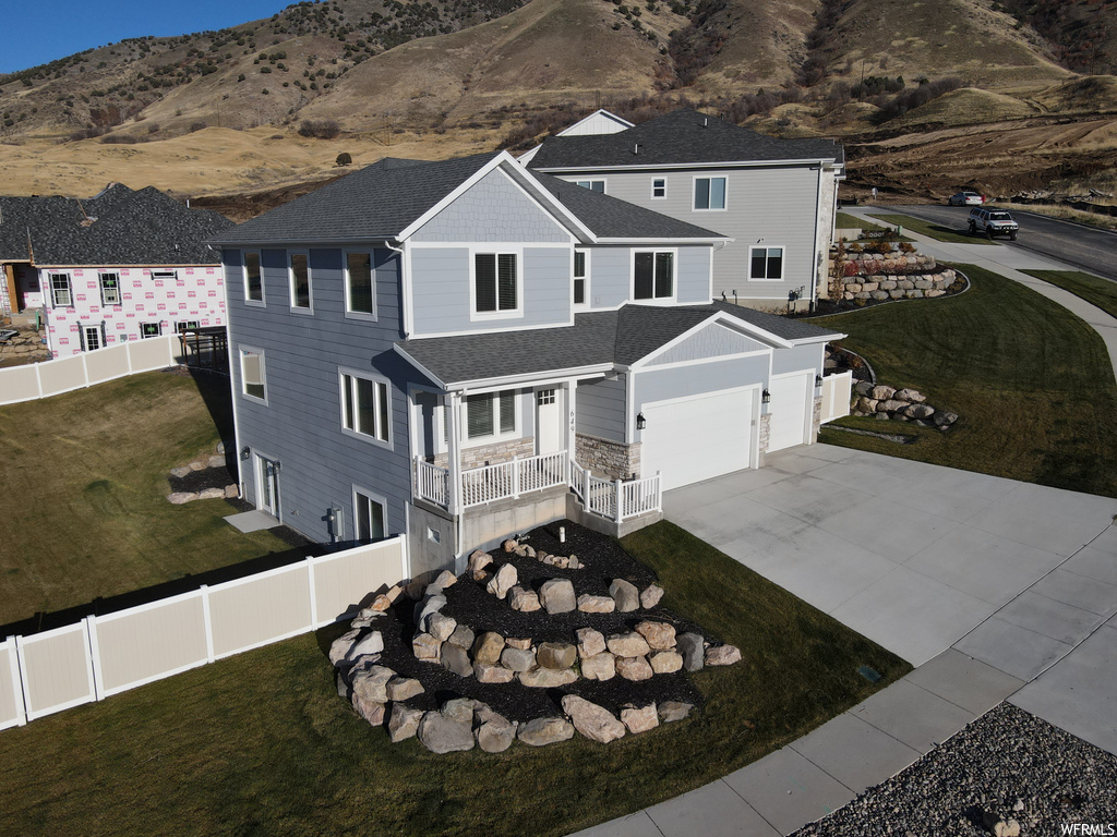 View of front of house with a front lawn, a garage, and a mountain view