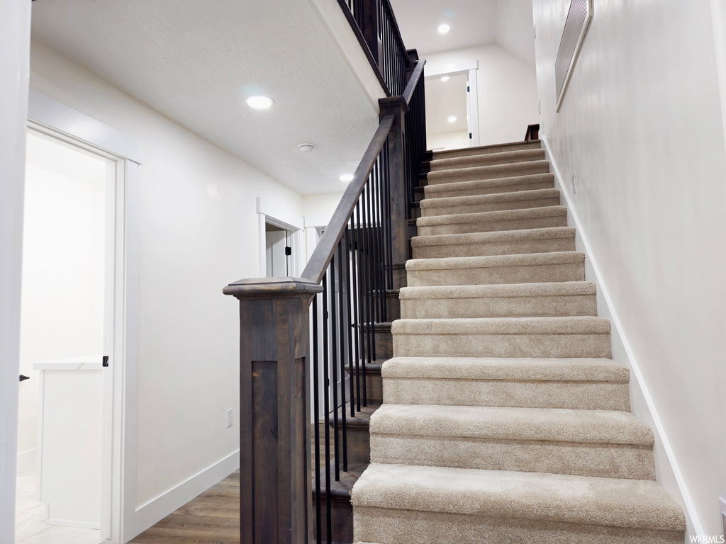 Stairs featuring hardwood / wood-style floors