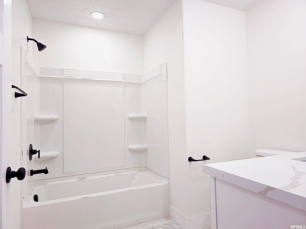 Full bathroom featuring vanity, toilet, a textured ceiling, and shower / bath combination