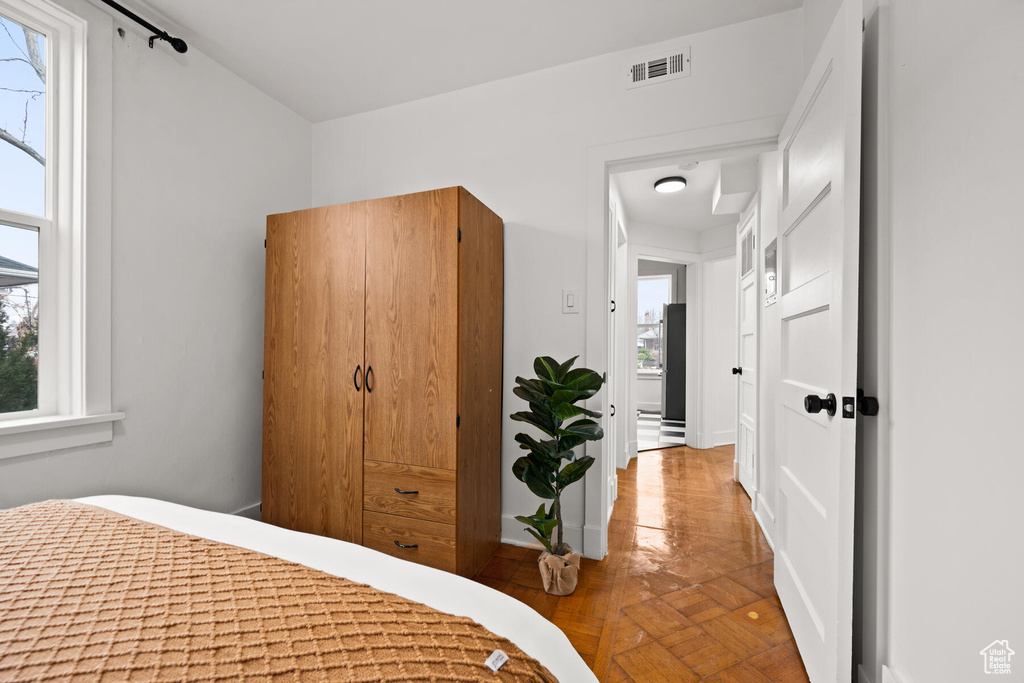 Bedroom with multiple windows and parquet floors