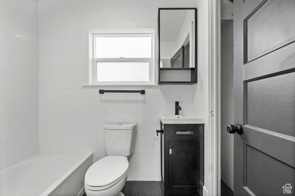 Full bathroom featuring vanity, toilet, tile walls, and tile floors