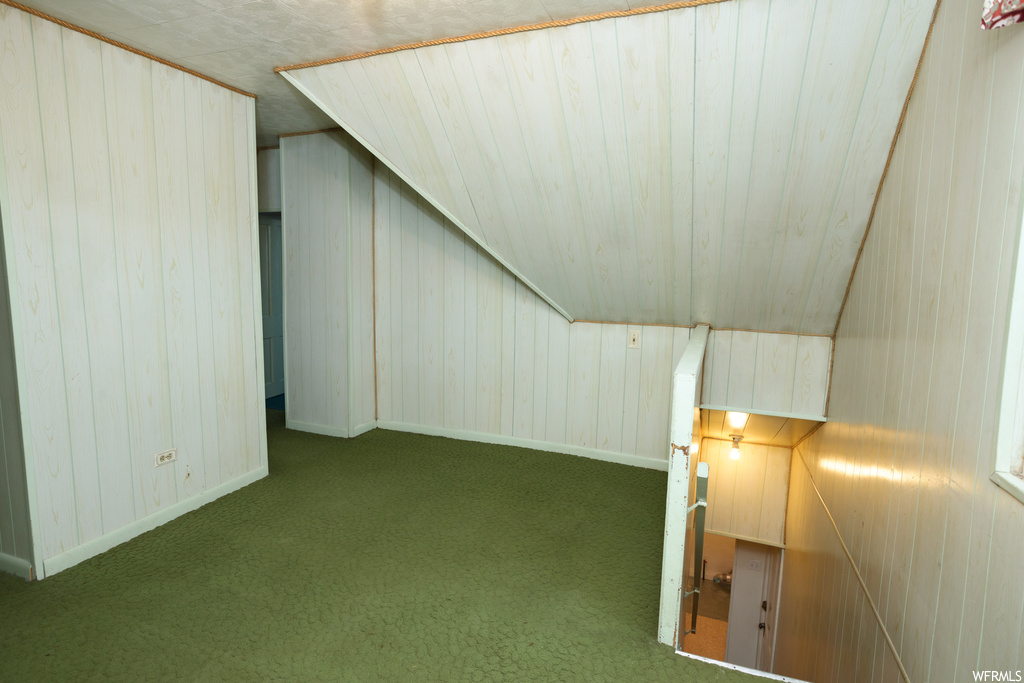Bonus room featuring dark colored carpet