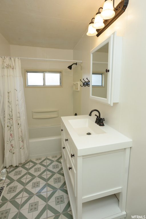 Bathroom with shower / bath combo with shower curtain, vanity with extensive cabinet space, and tile flooring