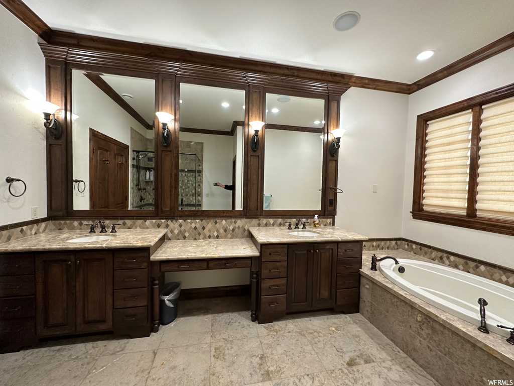 Bathroom featuring ornamental molding, tile flooring, dual sinks, and vanity with extensive cabinet space
