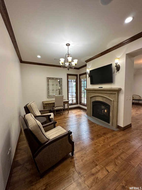 Living room with ornamental molding, dark hardwood / wood-style floors, and a notable chandelier