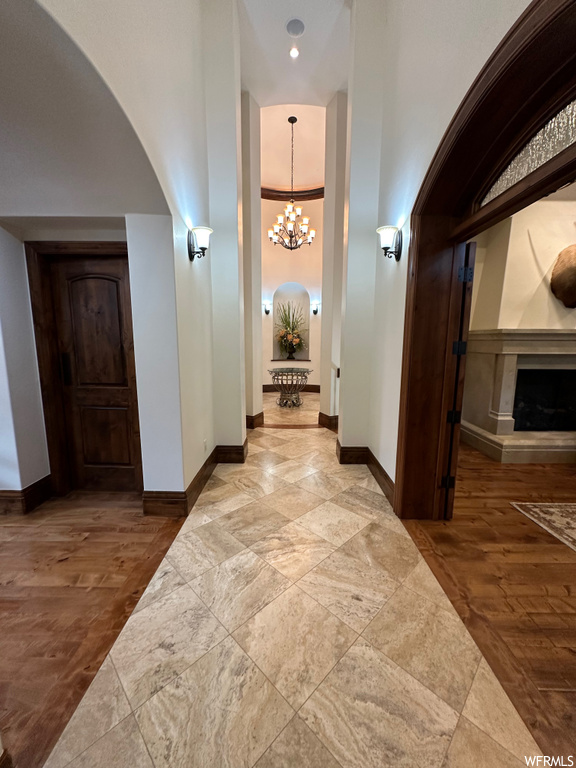 Hallway featuring ornamental molding, hardwood / wood-style floors, and a notable chandelier