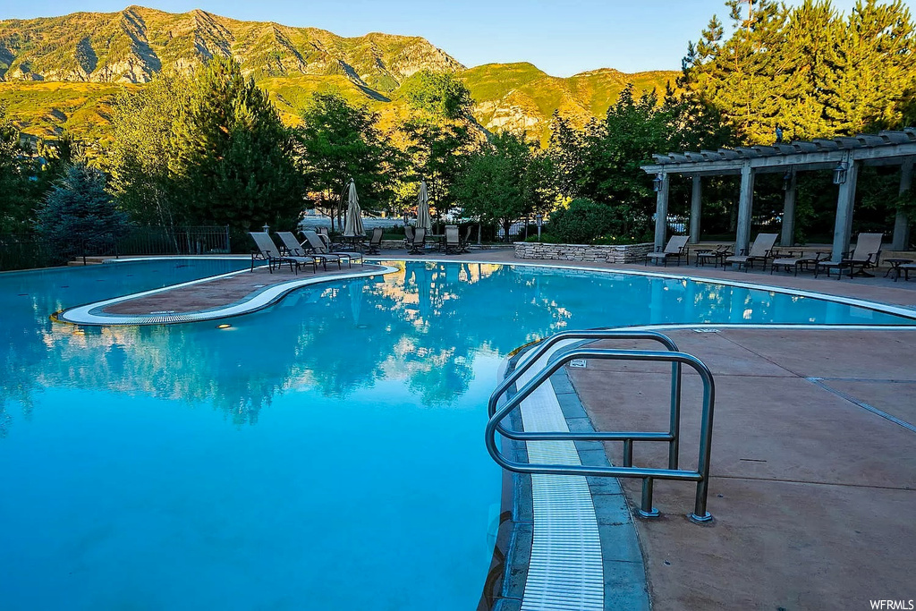 View of pool with a pergola and a mountain view