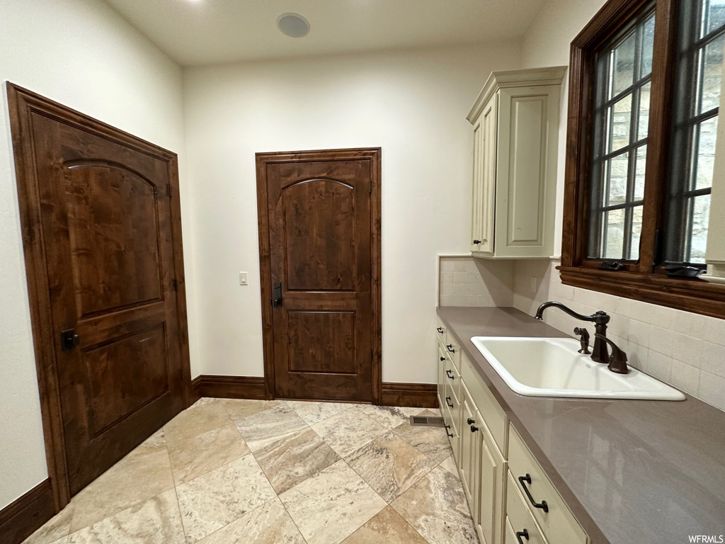 Bathroom with vanity, tile floors, and backsplash