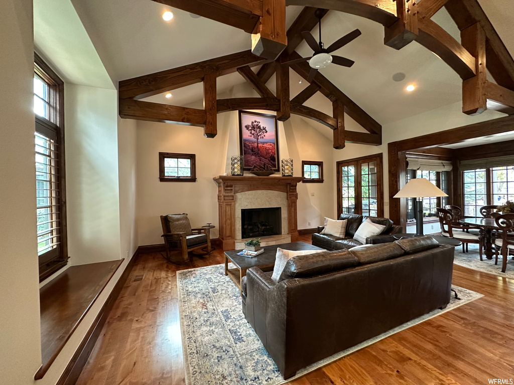 Living room with dark wood-type flooring, ceiling fan, and high vaulted ceiling