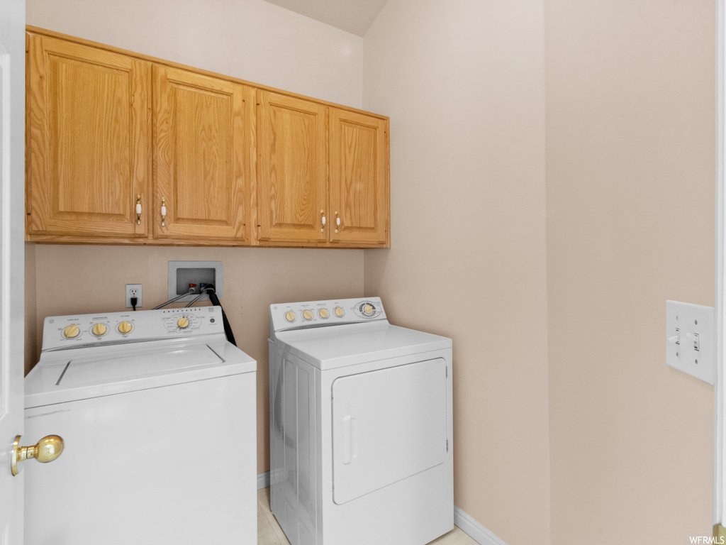 Laundry room with washer hookup, independent washer and dryer, and cabinets