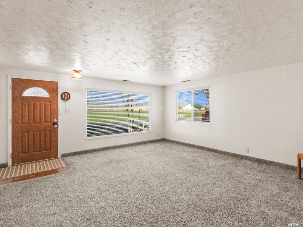 Carpeted entrance foyer with a textured ceiling