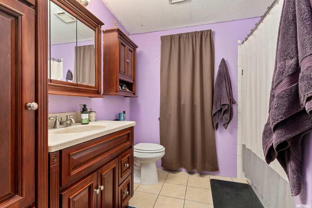 Bathroom with toilet, tile floors, and oversized vanity