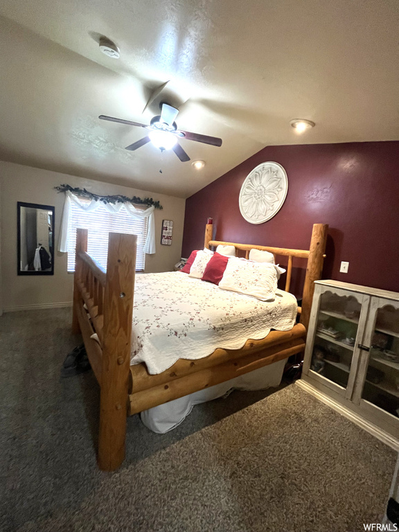 Bedroom featuring dark carpet, ceiling fan, and vaulted ceiling