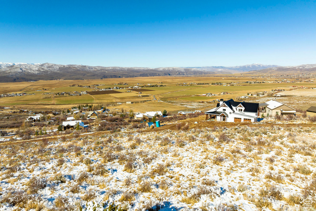 Snowy aerial view featuring a mountain view and a rural view