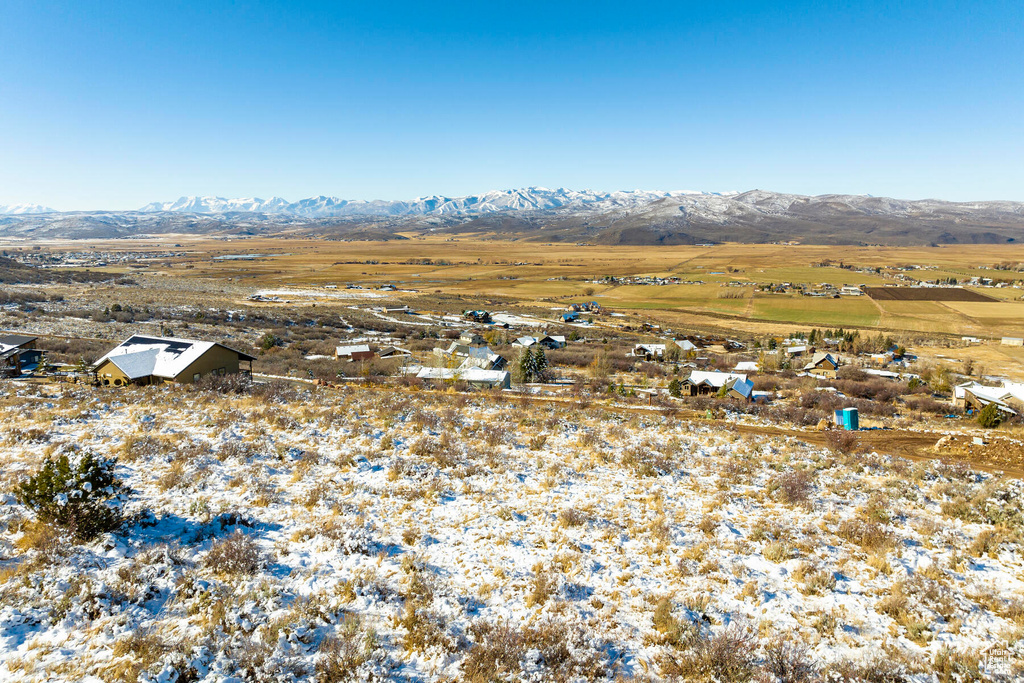 Snowy aerial view featuring a mountain view and a rural view