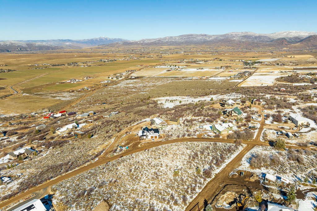 Snowy aerial view with a mountain view and a rural view