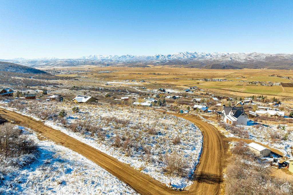 Snowy aerial view with a mountain view and a rural view