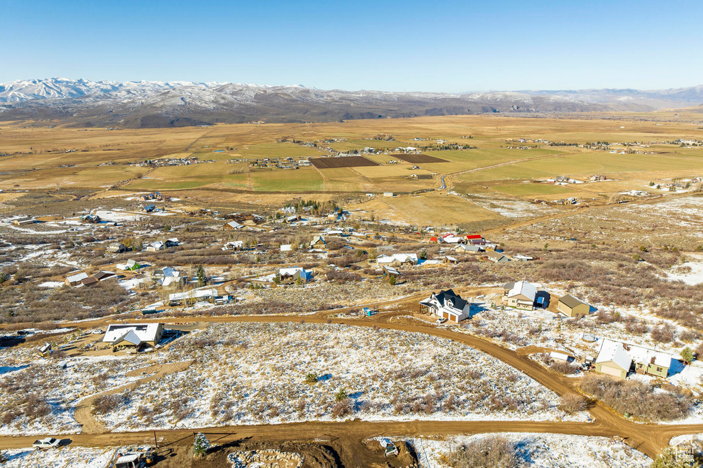 Snowy aerial view featuring a mountain view and a rural view