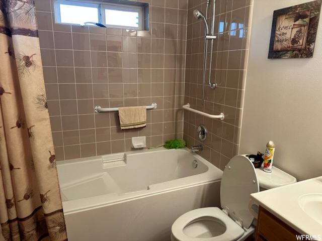 Full bathroom with vanity, shower / bath combo with shower curtain, and toilet
