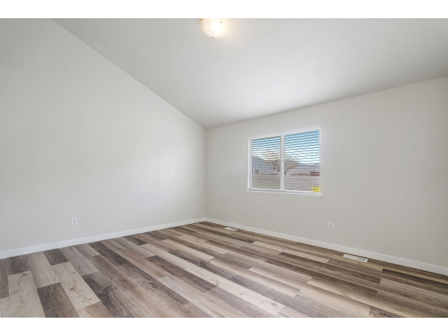 Empty room featuring vaulted ceiling and light hardwood / wood-style floors