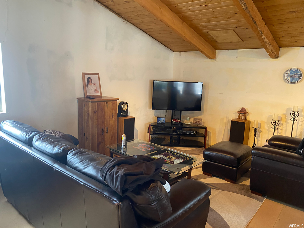 Living room with wood ceiling and vaulted ceiling with beams