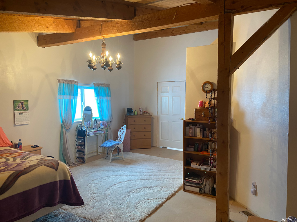 Carpeted bedroom with a chandelier and beam ceiling