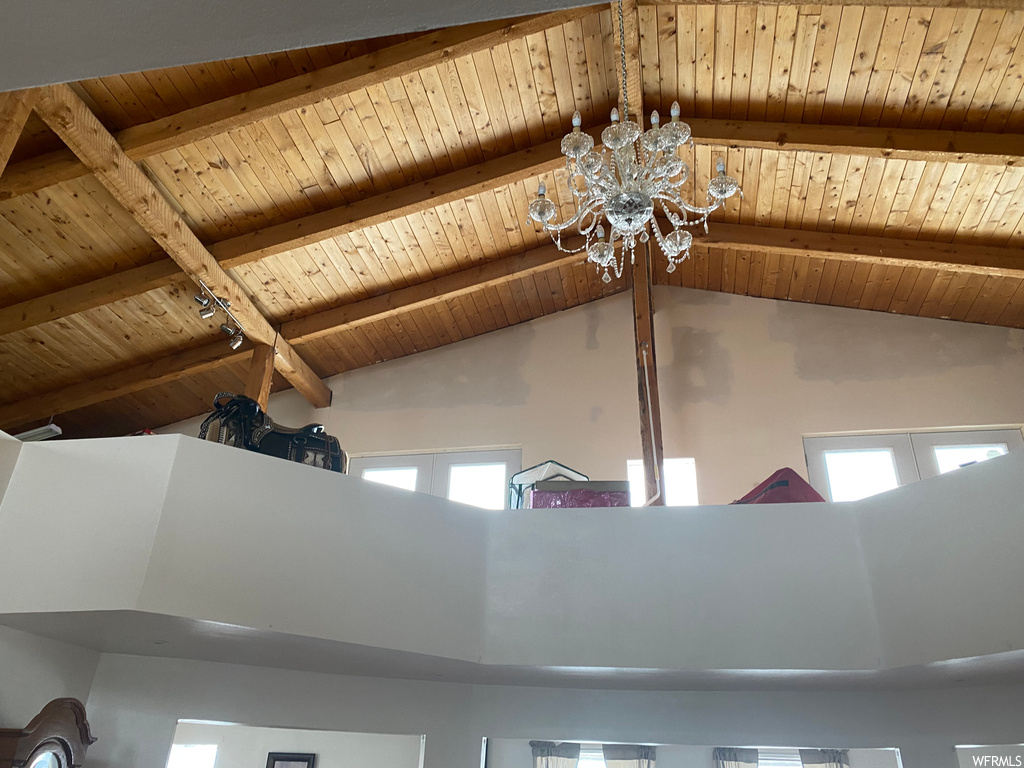 Room details featuring beam ceiling, wooden ceiling, and a notable chandelier