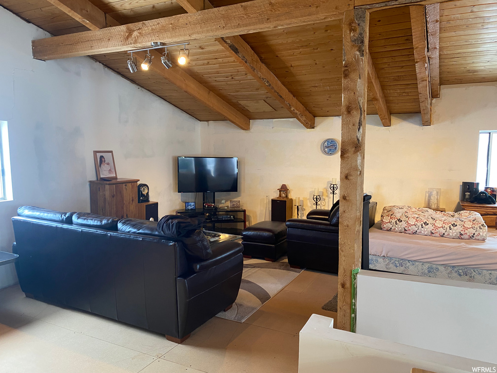 Tiled living room featuring wood ceiling, track lighting, and vaulted ceiling with beams