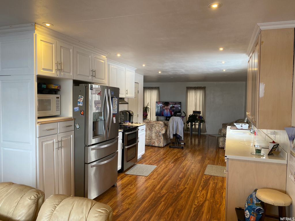 Kitchen featuring dark wood-type flooring, white cabinetry, and appliances with stainless steel finishes