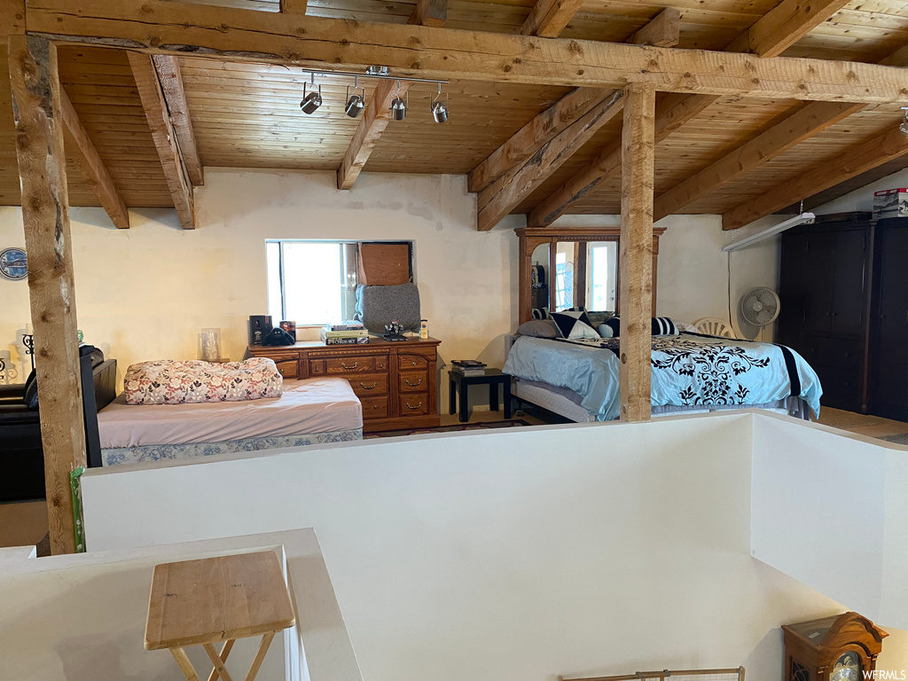 Bedroom with multiple windows, track lighting, and wood ceiling