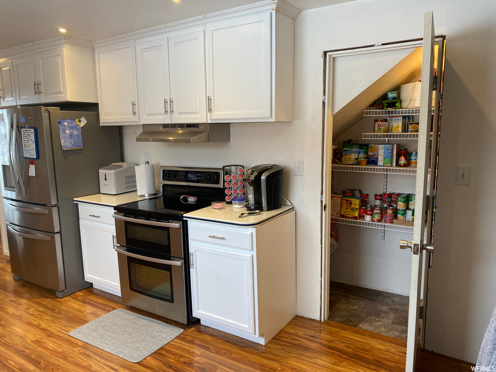 Kitchen featuring light hardwood / wood-style floors, white cabinetry, and appliances with stainless steel finishes