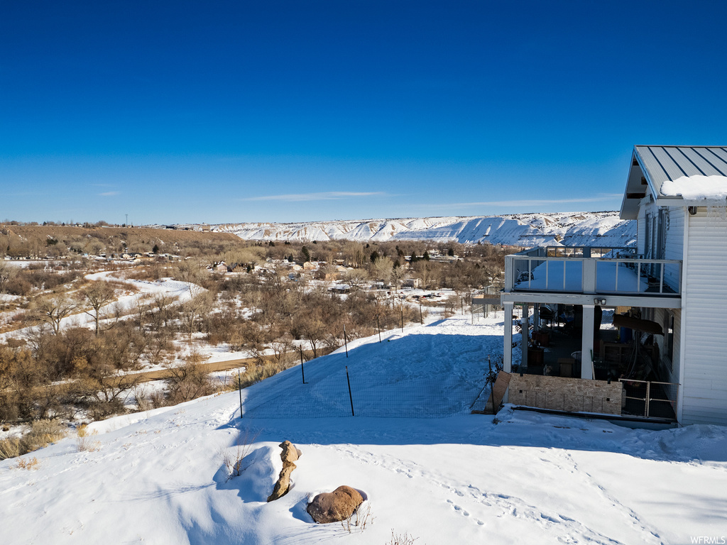 Snowy yard with a balcony and a mountain view