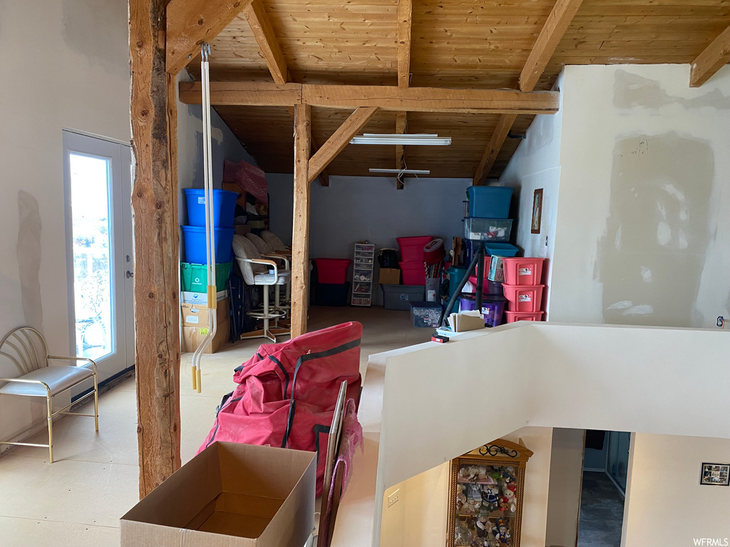 Living room featuring vaulted ceiling with beams, a healthy amount of sunlight, and wood ceiling