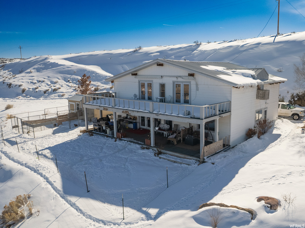 View of front of property with french doors and a balcony