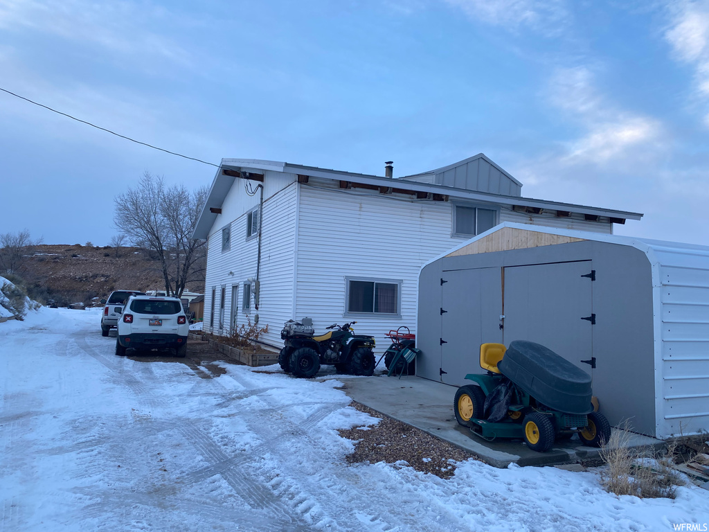 View of snowy exterior featuring a storage unit