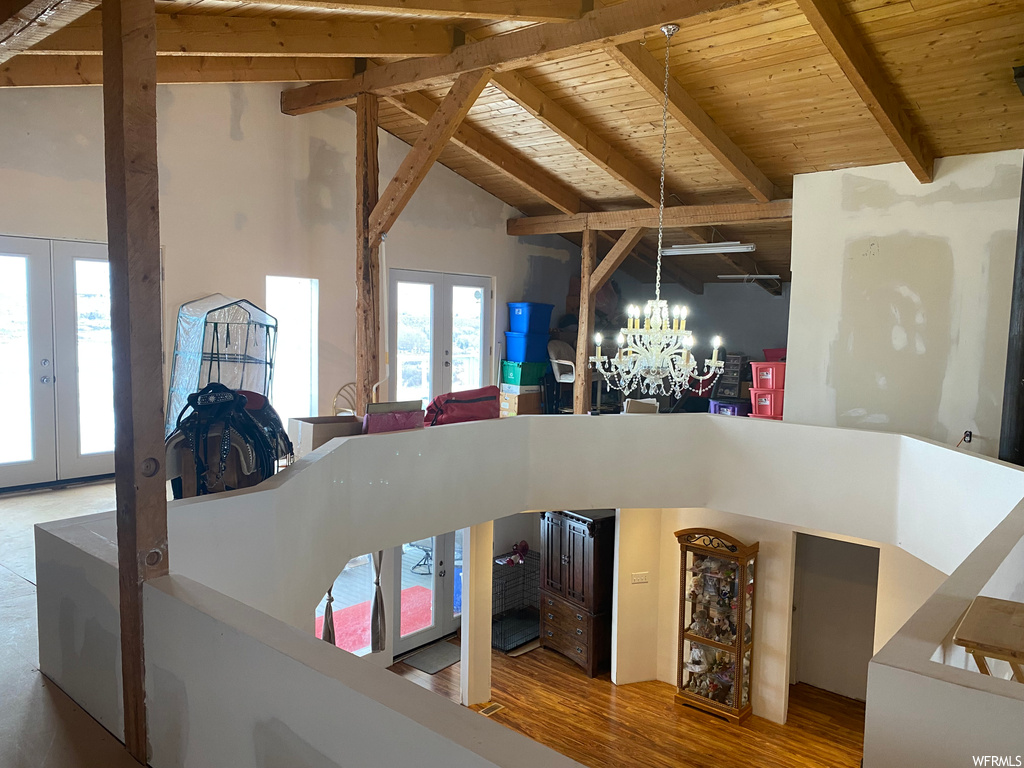 Interior space featuring an inviting chandelier, beam ceiling, french doors, and hardwood / wood-style floors