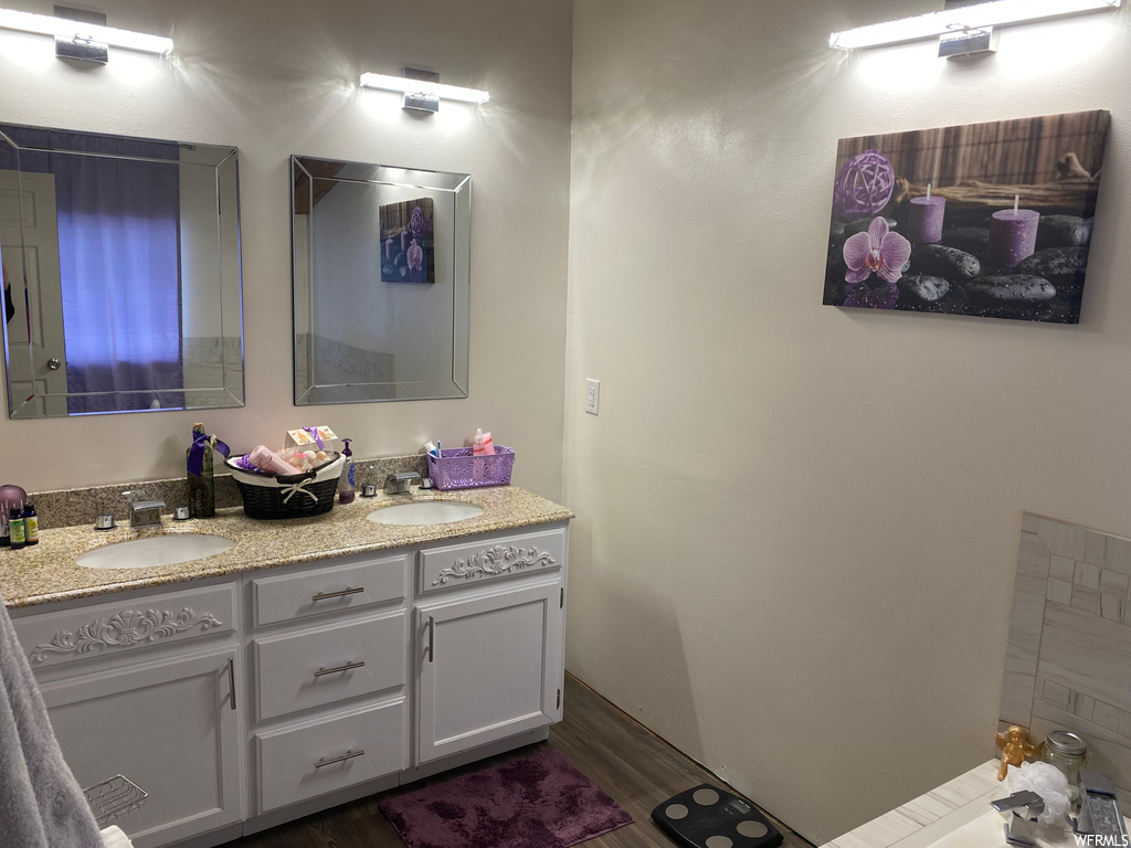 Bathroom featuring wood-type flooring and double vanity