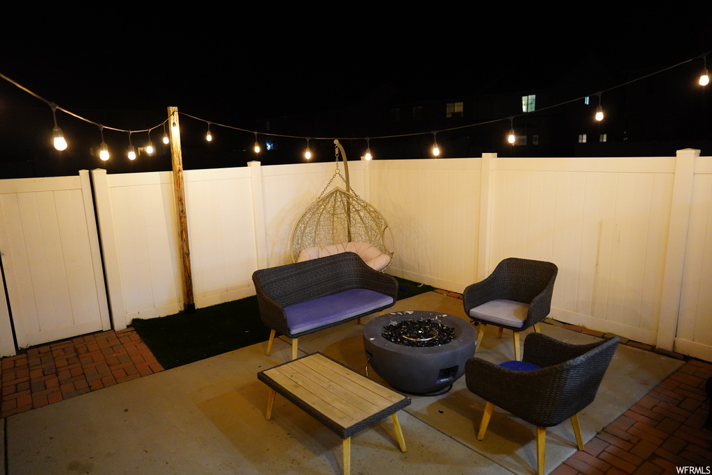 Patio terrace at night featuring an outdoor fire pit