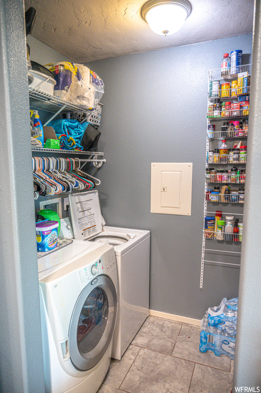 Laundry room with light tile floors and washing machine and dryer