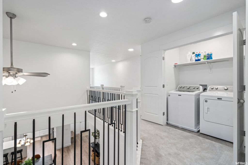 Clothes washing area with washer and dryer, light carpet, washer hookup, and ceiling fan