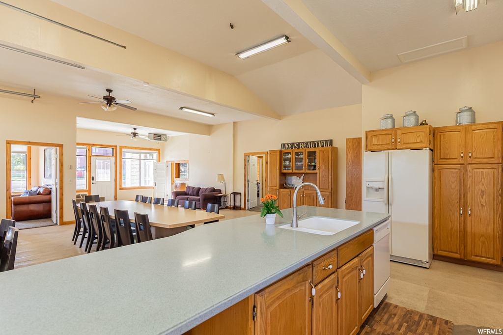 Kitchen with a healthy amount of sunlight, sink, white appliances, and ceiling fan