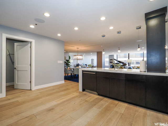 Kitchen featuring an inviting chandelier, sink, decorative light fixtures, and light hardwood / wood-style flooring