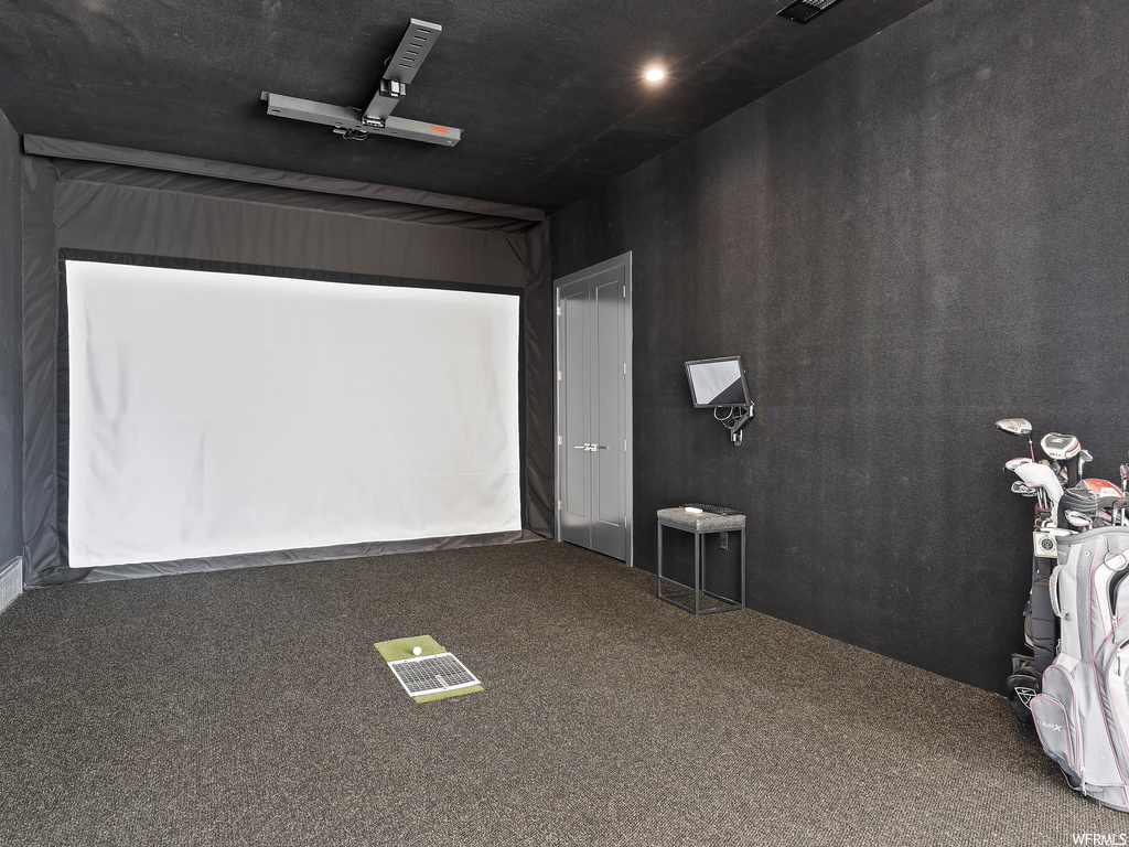 Carpeted cinema room with ceiling fan