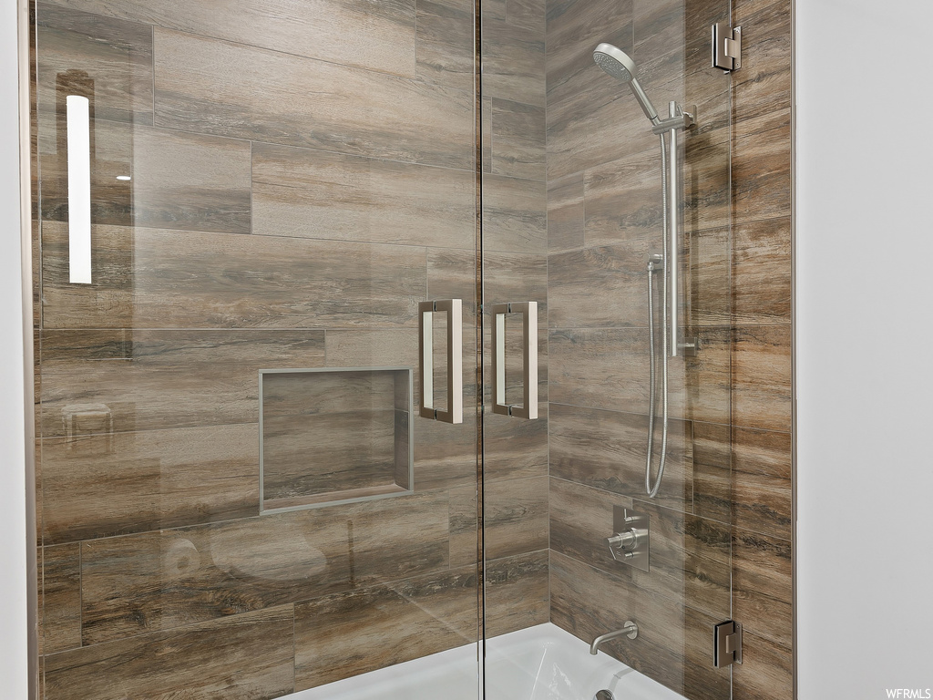 Bathroom featuring bath / shower combo with glass door