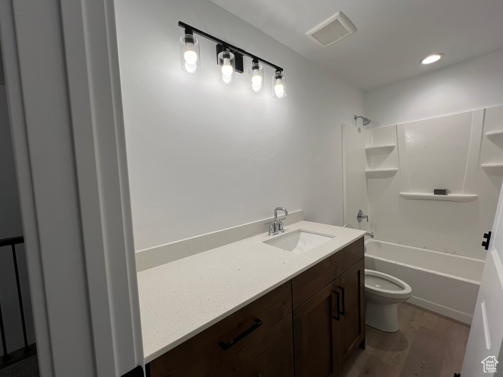 Full bathroom featuring shower / washtub combination, wood-type flooring, vanity, and toilet
