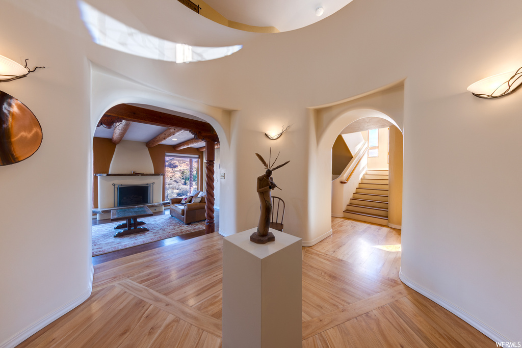 Hallway with beamed ceiling and light hardwood / wood-style floors