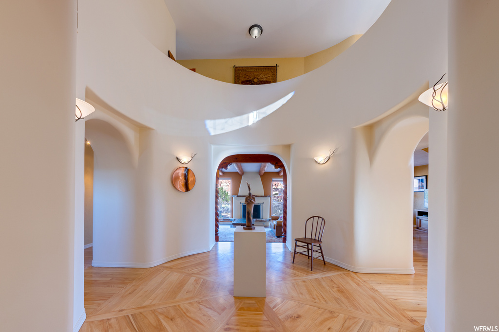 Interior space featuring light parquet floors and a towering ceiling