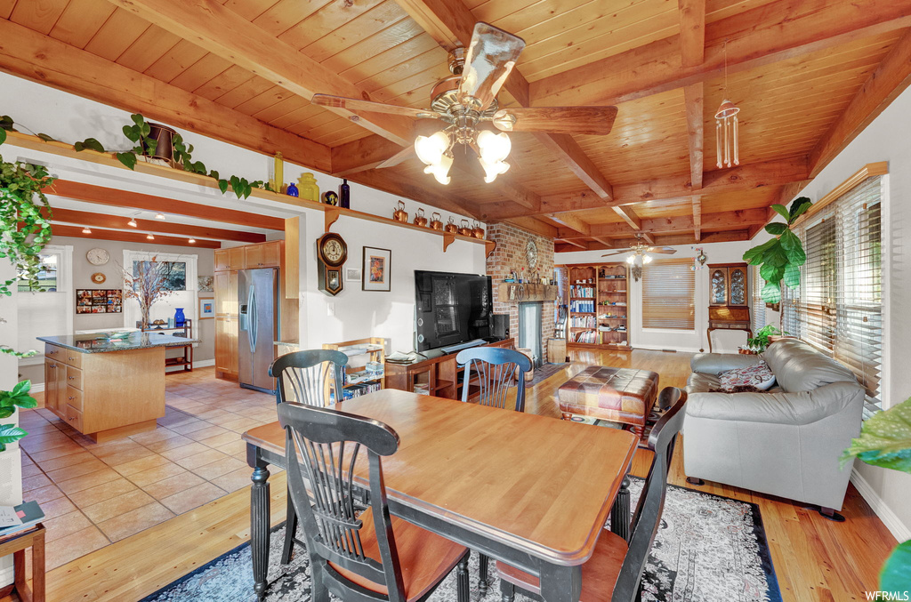 Dining area featuring wood ceiling, ceiling fan, light tile flooring, and beam ceiling