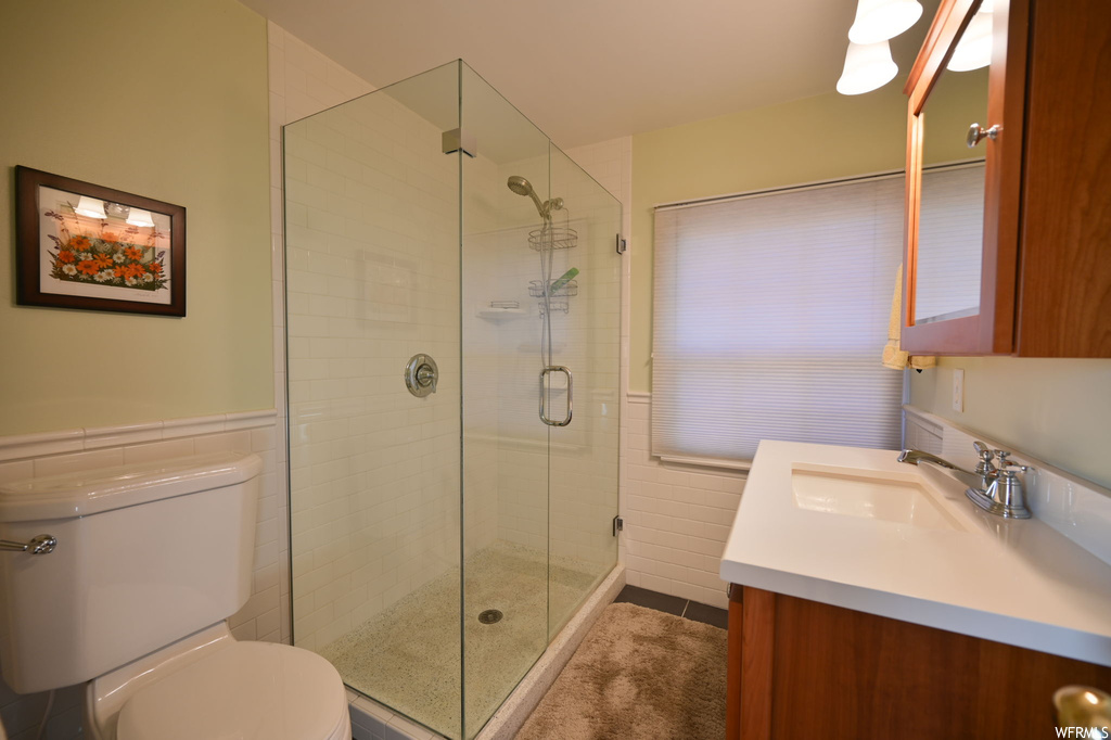 Bathroom with toilet, an enclosed shower, and vanity with extensive cabinet space